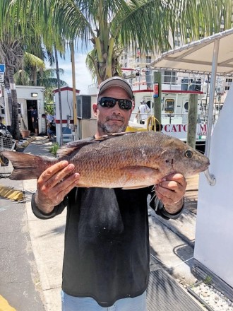 Waylan with a big mangrove snapper he caught on the Catch My Drift.