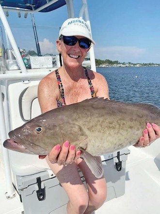 Rosina Rice hauling in grouper with Capt Don Rice of Fishwhacker Charters in PCB