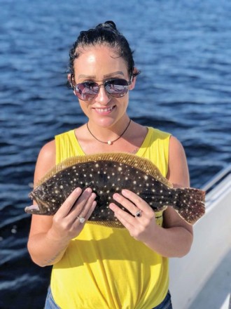 Tabitha hauling in flounder aboard Reel Screamer Charters with Capt. Chris Nguyen