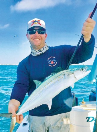 Happy angler with a Spanish mackerel caught aboard Bouncer’s Dusky 33.