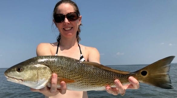 Julia Mahatekar proudly displays her redfish taken on the Eastern Shore of Mobile Bay.