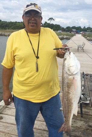 George Hill shows off a nice redfish caught across the street from Ft Gaines.