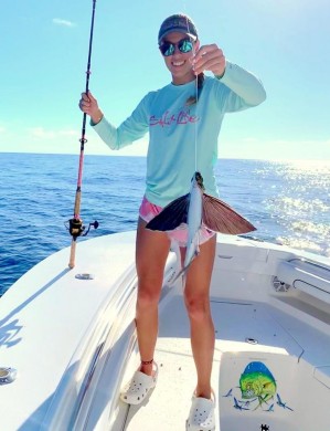 Melissa with a flying fish caught on rod while pitching a lure to a mahi!