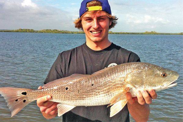 Spencer from Wisconson caught a 9 spot Mosquito Lagoon Redfish with Capt Michael Savedow.