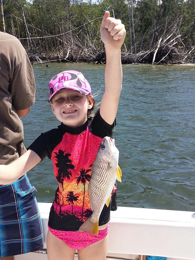 Olivia, 8, with her first redfish. PHOTO CREDIT: Bill Melson