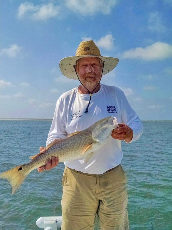 Captain Tommy Williams of Miss Judy Charters is holding up a nice red fish