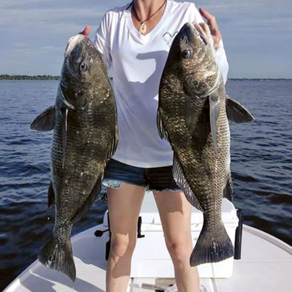 Michelle Wyatt holds two of the 21 black drum she caught and released during a fun day on the Indian River.