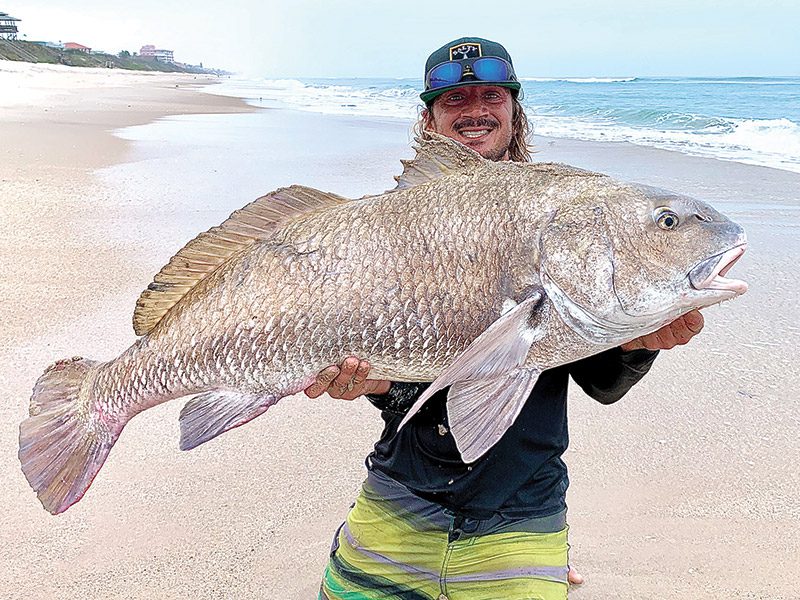 Capt. Lukas with a huge black drum he caught from the shore.