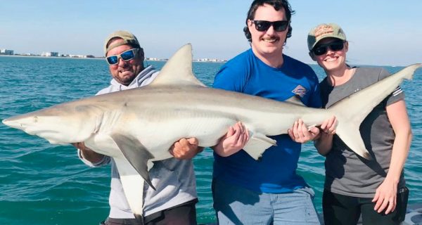 The strain is real as this great couple from Minnesota and Capt. Joe hoist up 6.5ft, 125 lbs. of full grown black tip shark as it turns to smile at the camera!