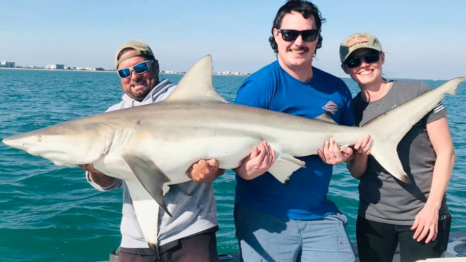 The strain is real as this great couple from Minnesota and Capt. Joe hoist up 6.5ft, 125 lbs. of full grown black tip shark as it turns to smile at the camera!