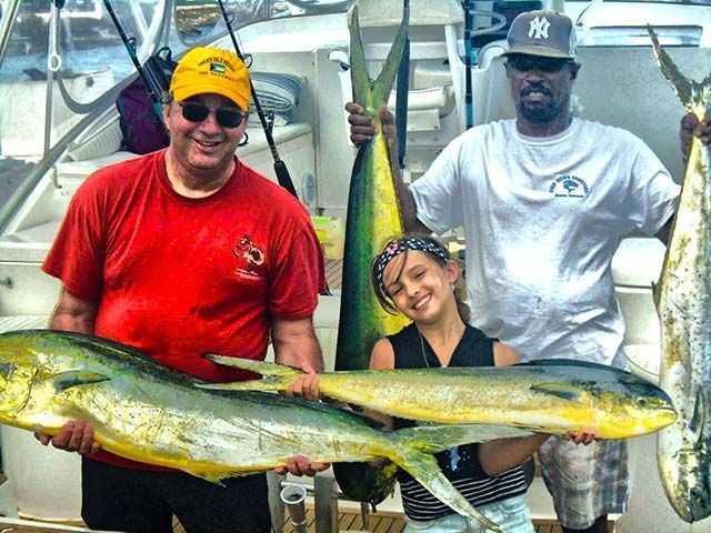 James Lapaseotes, daughter Demi and mate Timmy Smith showing off a great mahi catch. PHOTO CREDIT: Fish Rowe Charters.