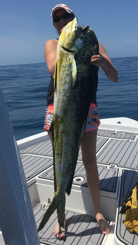 Corryn Alonge holding a beautiful dolphin that actually broke her reel. Photo courtesy of Rogue Wave Fishing Charters.