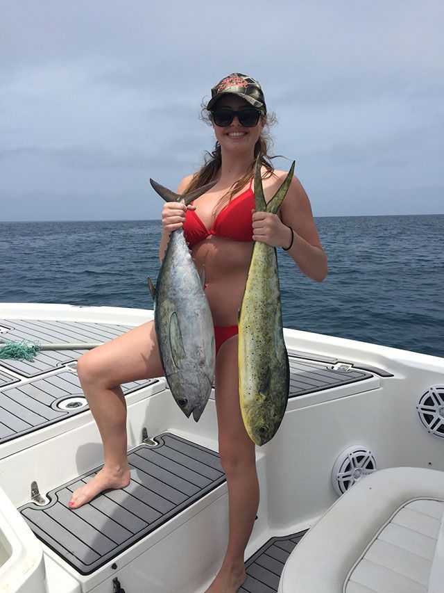 Destiny Maynard with her first black fin tuna and a dolphin. PHOTO CREDIT: Rogue Wave Fishing Charters.
