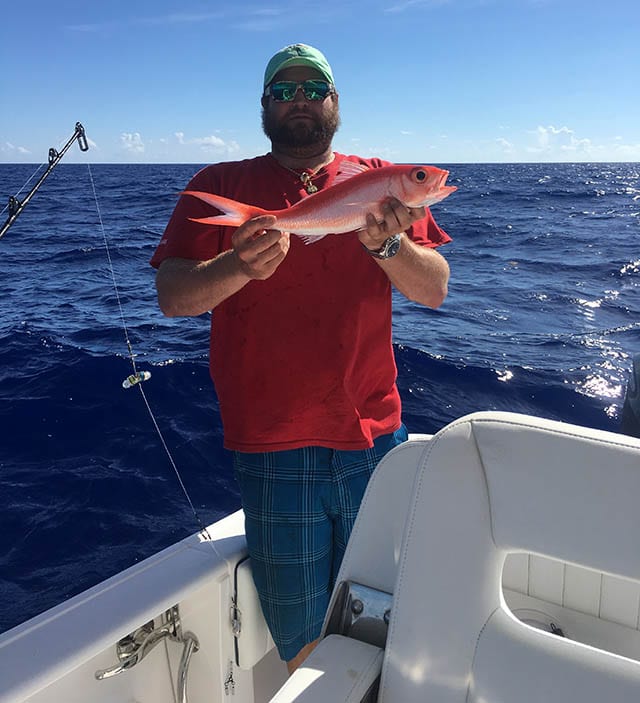 Capt. Travis Kelly with a queen snapper caught while fishing in 800 to 1,200 feet of water. PHOTO CREDIT: Gusto Charters & Guide Service.