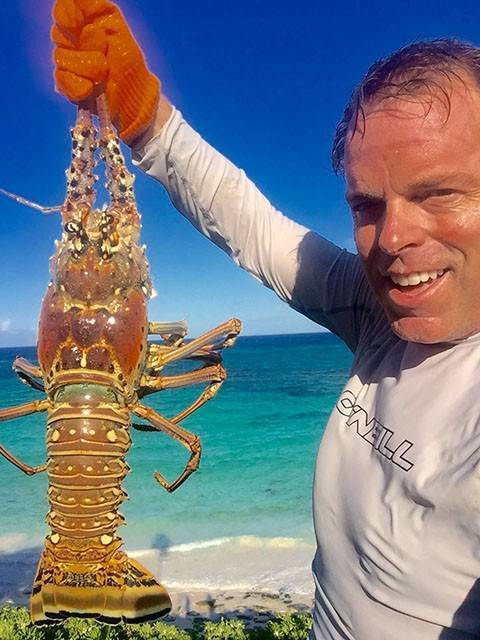 A productive afternoon in South Eleuthera in search of lobster. Robert Fortson proud of this big daddy found deep in a hole in about 5 to 8 feet of water. Photo courtesy of David Harbour and Marina.