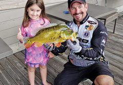 Five year old Kaylie Leavelle caught her first fish with a little help from Capt. Neal.
