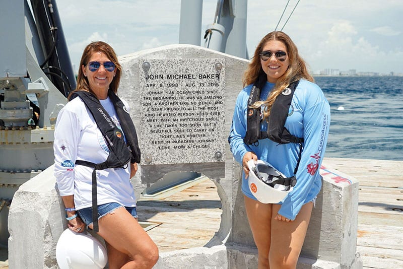 Johnny’s mother and sister, Jamie and Chloe Baker, in front of memorial plaque ready to be deployed