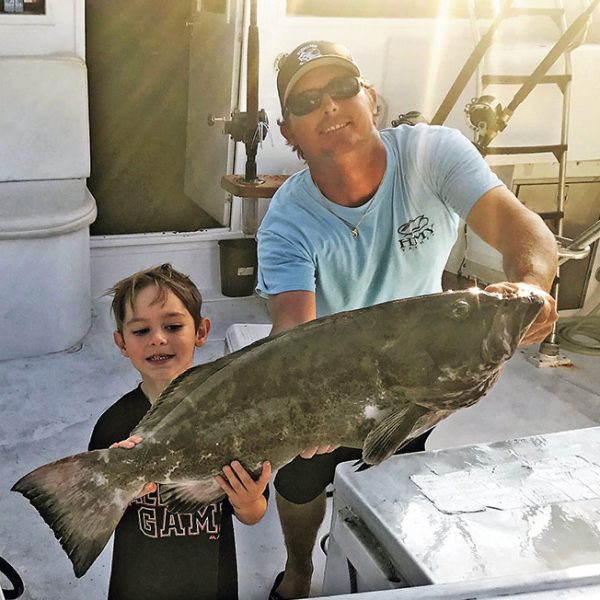 Capt Rod and Jayden with a nice black grouper.