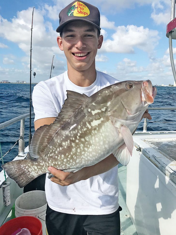 Frank with a nice red grouper aboard the Catch My Drift.
