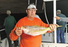 Gene with a nice yellowtail snapper caught night anchor fishing aboard the Catch My Drift.