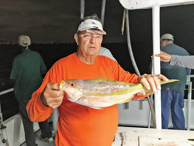 Gene with a nice yellowtail snapper caught night anchor fishing aboard the Catch My Drift.