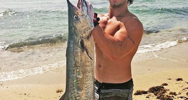 Joe Hector on the beach with a slob kingfish slayed from the kayak.