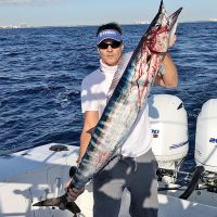Eddie Walters with a Christmas wahoo caught on a horse ballyhoo rigged behind a black and orange Islander.