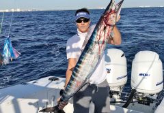 Eddie Walters with a Christmas wahoo caught on a horse ballyhoo rigged behind a black and orange Islander.