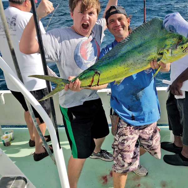 Justin holding a nice dolphin caught by this happy angler aboard the Catch My Drift.