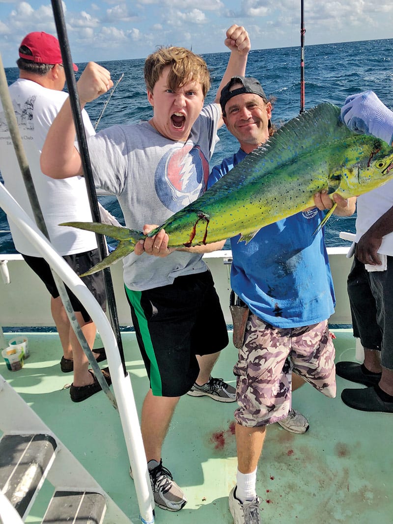 Justin holding a nice dolphin caught by this happy angler aboard the Catch My Drift.