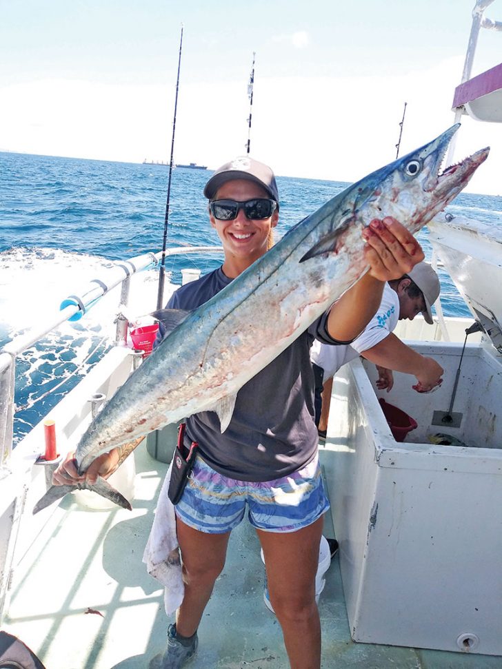 Kaylee with a monster kingfish caught aboard the Catch My Drift.