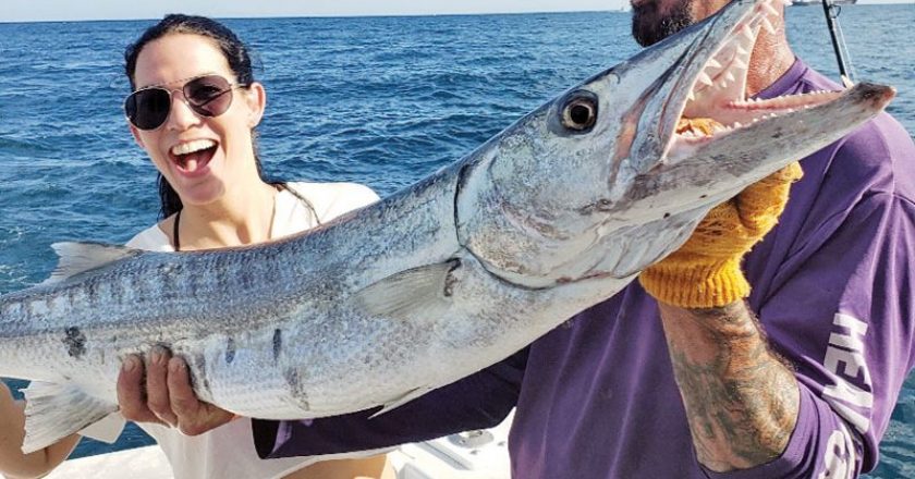 Kristine and Mick with a big Barracuda caught aboard the New Lattitude.