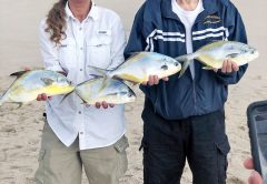 Happy couple show off their pompano reward after surf fishing with Cocoa Beach Surf Fishing Charters.
