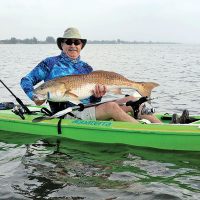 Dwight Bost with a huge redfish caught on the Indian River on a blue back Skitter Walk topwater plug. The red came partially out of the water to take the plug — an exciting start to an exhilarating fight!