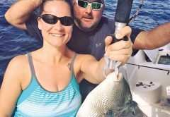 Amy Hayes getting some trigger fish action with Capt. Jason.