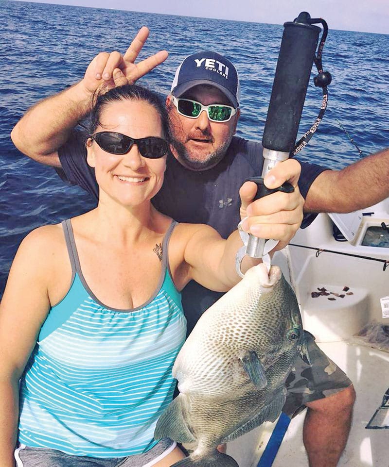 Amy Hayes getting some trigger fish action with Capt. Jason.