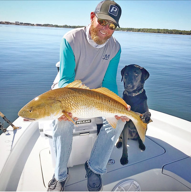 Capt. Jordan Todd and Murphy dog with a bull red sight fished.