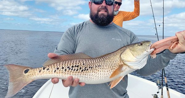 Daniel, here form Alabama, with a cool multi-spotted redfish he caught in St. Joe Bay fishing with Capt. Jordan Todd