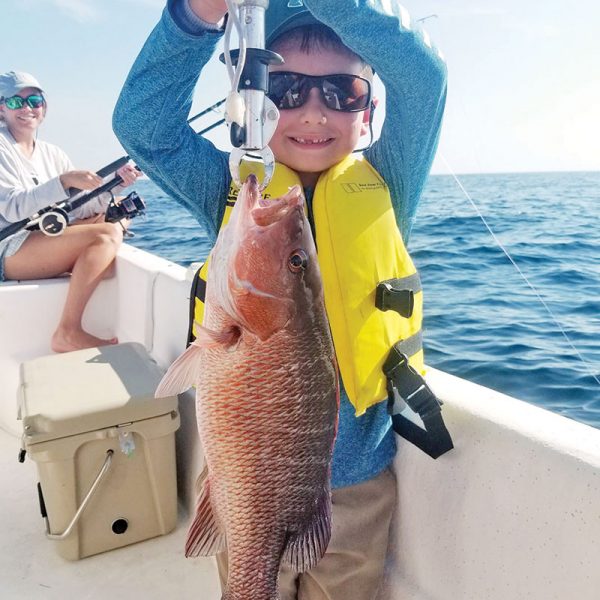 Gavin Gonterman from Corpus Christi, Texas cranking up mangrove snapper with Capt. Jason.