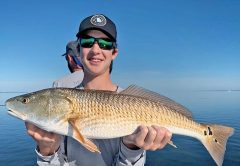 Jackson Williams, from Atlanta, with his first ever redfish, caught in St. Joe Bay.