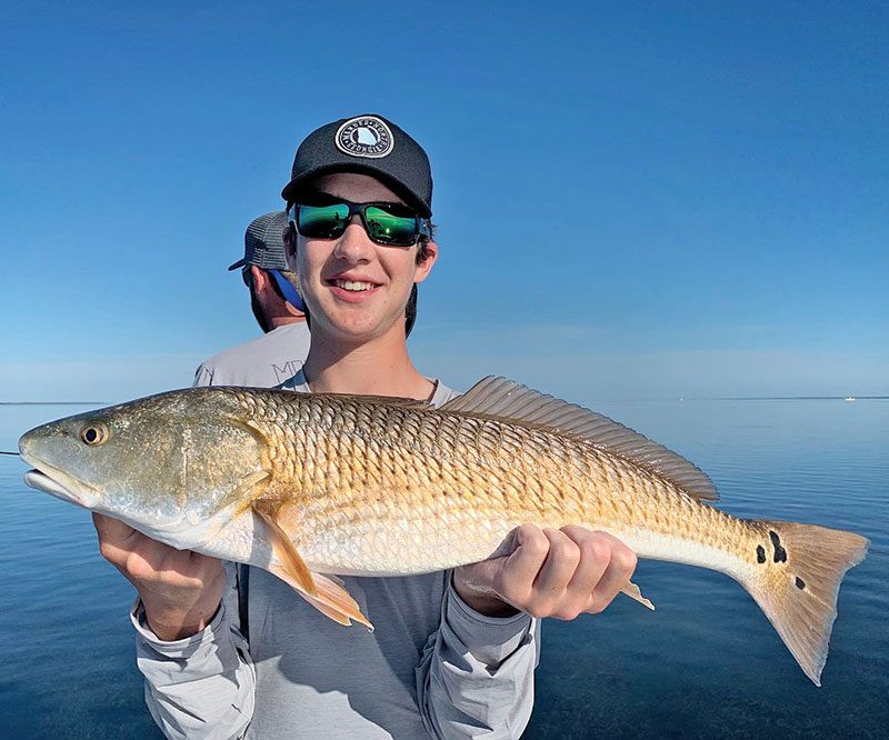 Jackson Williams, from Atlanta, with his first ever redfish, caught in St. Joe Bay.