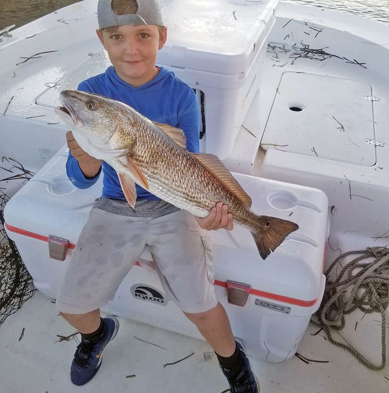 Jake Hewett bagging reds with Capt. Jason.