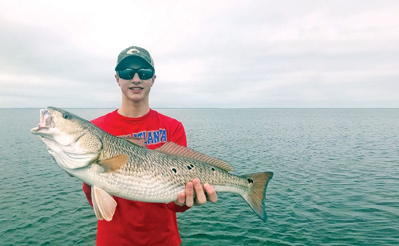 Jerrod Collins with an over slot redfish he caught in St. Joe bay on a Johnson gold spoon.