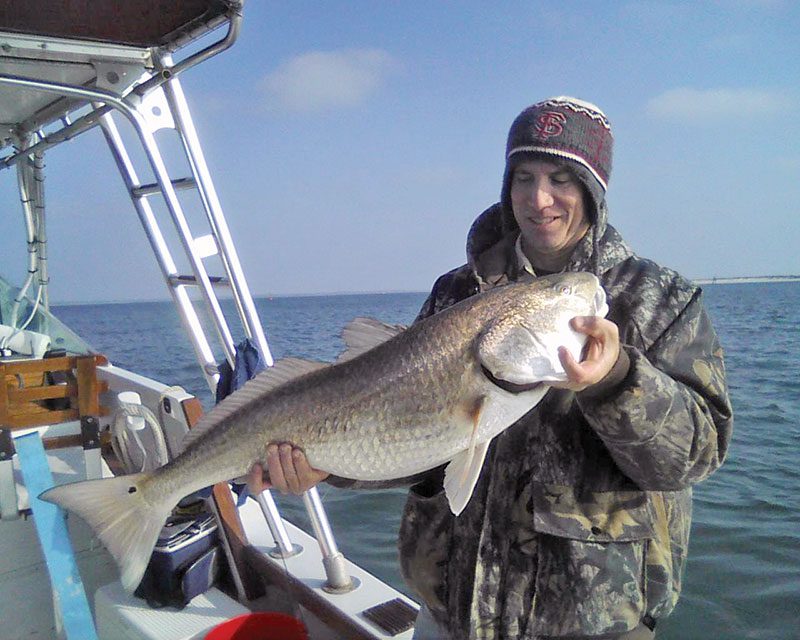 John Massy with a Winter bull red fishing with Capt. Chester Reese Natural World Charters.