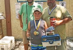 Pinfish Grand National Winner Caleb Hicks being awarded his medal, tackle box, hat and new fishing rod.