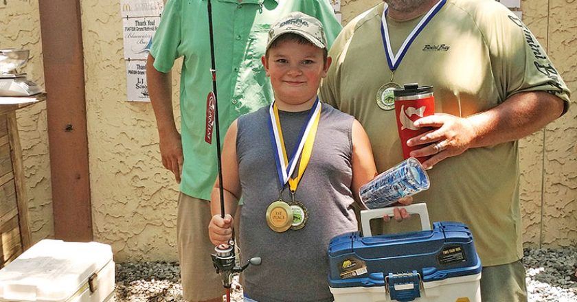 Pinfish Grand National Winner Caleb Hicks being awarded his medal, tackle box, hat and new fishing rod.