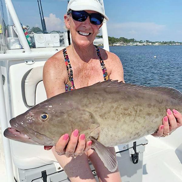 Rosina Rice hauling in grouper with Capt Don Rice of Fishwhacker Charters in PCB.