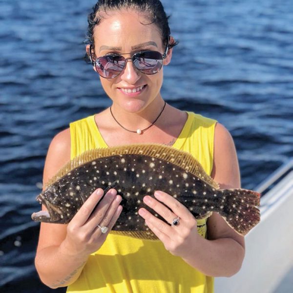 Tabitha hauling in flounder aboard Reel Screamer Charters with Capt Chris Nguyen