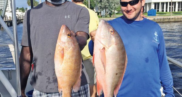 Evan and Mike with a couple nice snappers caught deep sea fishing aboard Catch My Drift.