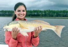 Abbey Posey with a stud 27 inch redfish caught on the new Storm Coastal paddle tail in mullet color.